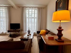 a living room with a couch and a lamp at Maison Mǔso in Dinant