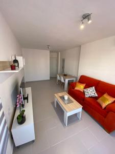 a living room with a red couch and a table at Áticobarco in La Antilla +4 photos