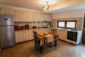eine Küche mit einem Tisch und einem Edelstahlkühlschrank in der Unterkunft Roua Dimineții in Rucăr