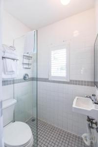 a white bathroom with a toilet and a sink at Andy's Attic in Key West