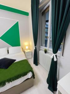 a bedroom with a green bed and a window at 22CAP apartment in Milan
