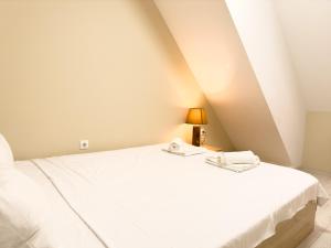 a bedroom with a white bed and a lamp at Elite Business Residence with Free Gym Pass, Street Parking and Full Office Setup in Plovdiv