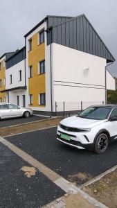 a white car parked in front of a building at Apartament z dużym ogródkiem in Rzeszów