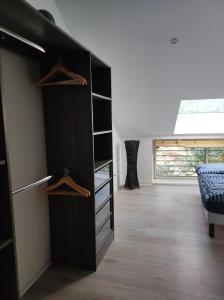 Una habitación con un armario negro con estantes de madera. en Gîte Aux murmures de la Streng, en Ribeauvillé