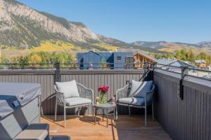 un balcon avec deux chaises et une table avec des fleurs dans l'établissement Academy Place | Larkspur, à Crested Butte