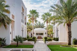 ドーハにあるSharq Village & Spa, a Ritz-Carlton Hotelのヤシの木と白い建物のある中庭 +37枚の写真