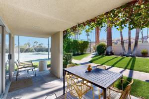 a table and chairs on a patio with a view of a yard at The CoCo Cabana Unit 31 Permit# 4451 in Palm Springs