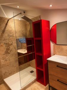 ein Bad mit einer Dusche und einem roten Schrank in der Unterkunft Le Cœur du Village in Sainte-Cécile-les-Vignes + 10 Fotos