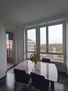 a dining room with a table and chairs and windows at STANZA matrimoniale metro M5 - Bignami, Carroponte in Sesto San Giovanni