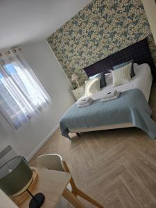 a bedroom with a large bed and a window at Hôtel L'ideal le Mountbatten in Arromanches-les-Bains