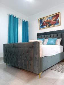 a bedroom with a large bed with blue curtains at Boca del Mar III, apartamento 411 in Boca Chica