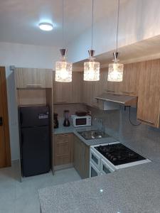 a kitchen with a black refrigerator and a stove top oven at Boca del Mar III, apartamento 411 in Boca Chica