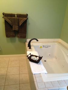 a bathroom with a bath tub with a basket on it at Smugglers Notch Inn in Jeffersonville