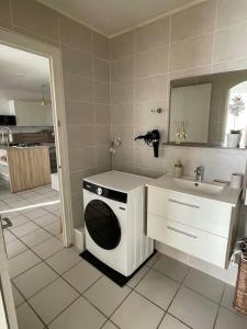 ein Badezimmer mit Waschmaschine und Waschbecken in der Unterkunft Nid douillet a la campagne in Saint-Jean-de-Bournay