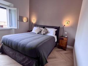 Un dormitorio con una cama grande y una ventana. en Artieri Suites, Piazza Maggiore, en Bolonia