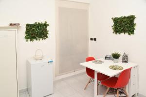 a kitchen with a white table and red chairs at Incoming Quartieri Spagnoli in Naples +34 photos