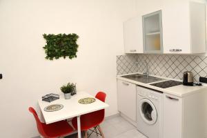 a kitchen with a table and a washing machine at Incoming Quartieri Spagnoli in Naples