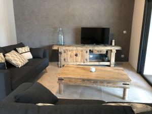 Gîte Chez Marcel & Marthe في Saint-Front-la-Rivière: غرفة معيشة مع أريكة وطاولة قهوة