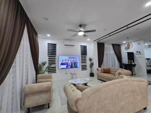 un soggiorno con due divani e una TV di The Bangau Cottage a Sungai Petani