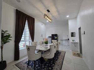 una sala da pranzo bianca con tavolo e sedie di The Bangau Cottage a Sungai Petani