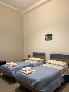 deux lits dans une chambre avec des serviettes dessus dans l'établissement Gi Gi Affittacamere, à Syracuse