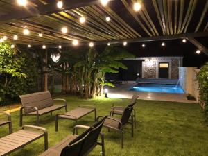 a patio with chairs and a swimming pool at night at Gîte Chez Marcel & Marthe in Saint-Front-la-Rivière
