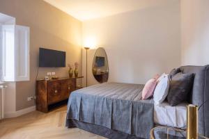 1 dormitorio con cama, espejo y TV en Artieri Suites, Piazza Maggiore, en Bolonia
