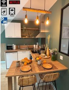 a kitchen with a table with oranges on it at Studio Bois flotté Cherbourg Netflix Parking in Cherbourg en Cotentin