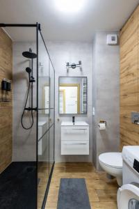 a bathroom with a shower and a toilet and a sink at VIP Apartamenty Wieniawskiego in Rzeszów