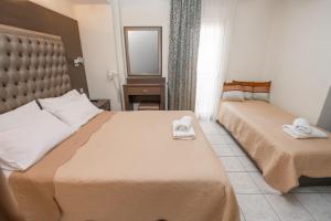 a hotel room with two beds with towels on them at Hotel Avra in Perea