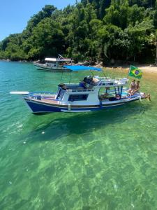 a group of people sitting on a boat in the water at Passeio de barco em Paraty in Paraty +11 photos