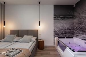 una camera con vasca e un letto di Apartament z Jacuzzi & Sauna Chillout a Kołobrzeg