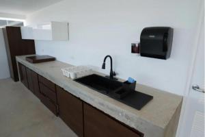 Trujillo AltoにあるVilla Familiar frente al mar Puerto Ricoのキッチン(シンク付)、テレビ +6枚の写真