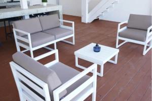 Trujillo AltoにあるVilla Familiar frente al mar Puerto Ricoの椅子2脚とテーブルのあるリビングルーム