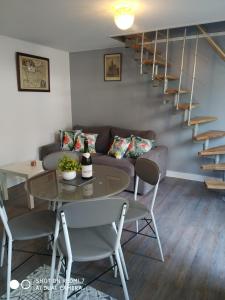 a living room with a couch and a table at Charmant petit logement in Bayeux