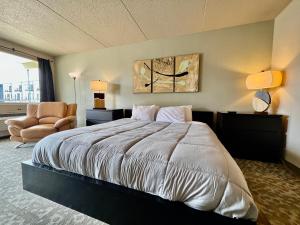 ein Schlafzimmer mit einem großen Bett und einem Stuhl in der Unterkunft Lindell Motor Lodge - Downtown Cedar Falls Studio With Free Gated Parking! in Cedar Falls + 6 Fotos