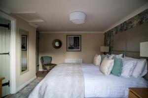 a bedroom with a large white bed and a chair at Brewers Inn in Cambridge