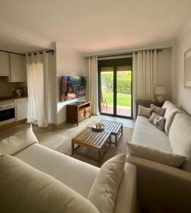 ein Wohnzimmer mit Sofa und Tisch in der Unterkunft COSTA GALERA Apartamento con piscinas jardín y un baño cercano a la playa in Estepona + 14 Fotos