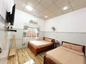 a room with two beds and a television in it at Nhân Duyên Hotel in Vĩnh Hy