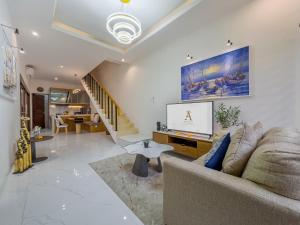 a living room with a couch and a tv at De Amelia Villa Seminyak by Nagisa Bali in Seminyak
