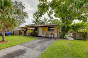 una casa amarilla con sillas en un patio en 8 Mi to Beach Pet-Friendly Fort Lauderdale Studio, en Fort Lauderdale