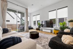 a living room with a couch and a tv at Rainey St Retreat - Cowboy Pool & Urban Chic in Austin