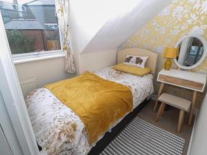 a small bedroom with a bed and a window at Skyelands in Wooler