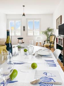 a dining room table with plates and wine glasses at À 5 min des Plages, Jardin Privé in Royan +19 photos