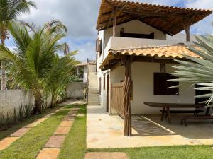 a house with a table and a bench in a yard at Exclusive House Preá in Cruz