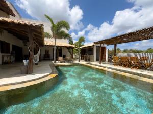 a swimming pool with blue water in a house at Exclusive House Preá in Cruz