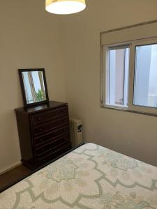 a bedroom with a bed and a dresser with a mirror at Casa 18 in Évora