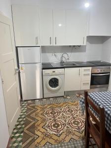 a kitchen with a refrigerator and a washing machine at Casa 18 in Évora