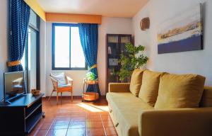 a living room with a couch and a tv at Beach Breeze, Playa Santiago in Playa de Santiago