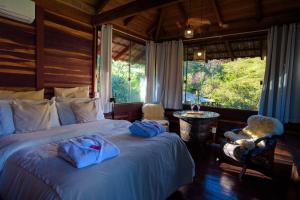 a bedroom with a bed with blue towels on it at Casa do Lago Caparaó in Pedra Menina
